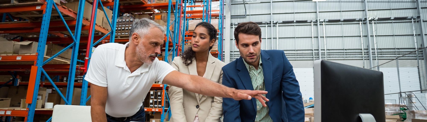 Workers in warehouse discussing logistics